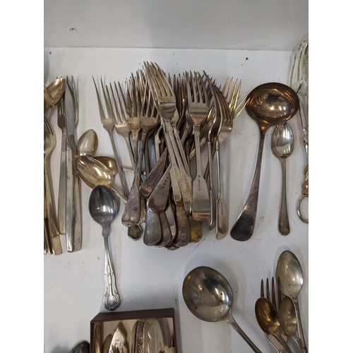 183 - A collection of silver plated flatware to include two pairs of tongs, a fish slice along with mother... 