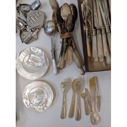 183 - A collection of silver plated flatware to include two pairs of tongs, a fish slice along with mother... 