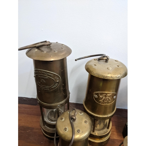 239 - A collection of seven miner's lamps to include The Protector Type 1A, another similar and reproducti... 