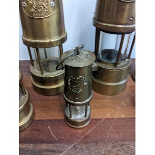 239 - A collection of seven miner's lamps to include The Protector Type 1A, another similar and reproducti... 