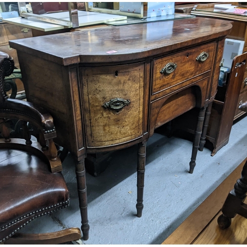 502 - A 19th century bow fronted sideboard with two long drawers, flanked by two deep drawers with brass h... 