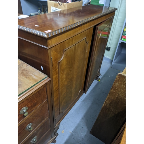 503 - An early 20th century cupboard with moulding on the top, two decorated panel doors revealing a shelv... 