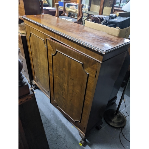 503 - An early 20th century cupboard with moulding on the top, two decorated panel doors revealing a shelv... 