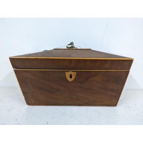 285 - An early 20th century mahogany tea caddy of sarcophagus form with a hinged lid, revealing two interi... 