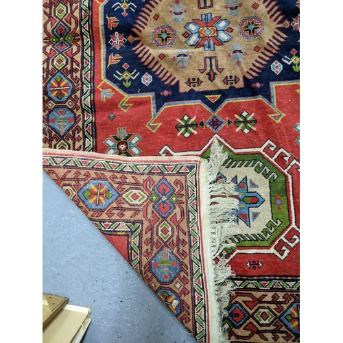 328 - A vintage hand woven Afghan style rug, three elephant gulls on a red ground, stylized floral motifs,... 