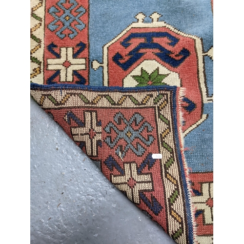 329 - A hand woven Turkish style runner, five central floral medallions on a sky blue ground, double guard... 