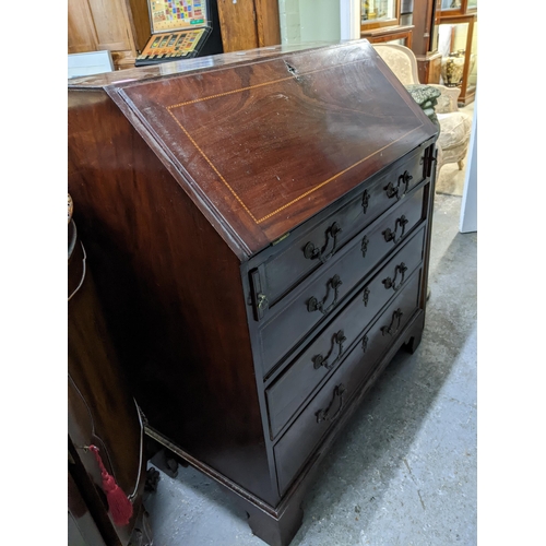 343 - A Georgian mahogany bureau with ebony and boxwood stringing, fall flap revealing a fitted pigeonhole... 