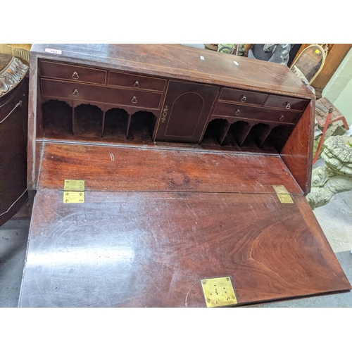 343 - A Georgian mahogany bureau with ebony and boxwood stringing, fall flap revealing a fitted pigeonhole... 