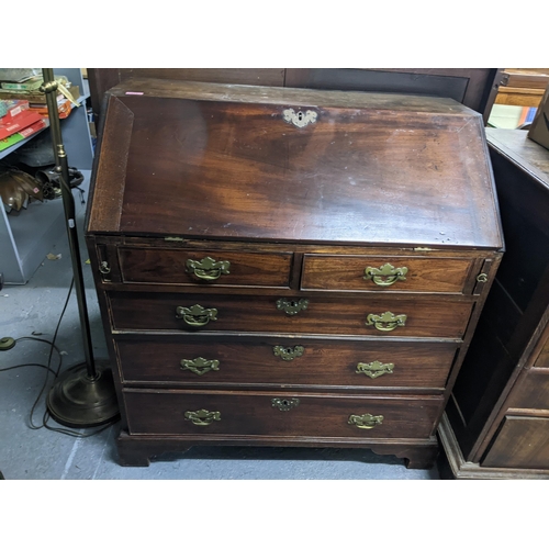 498 - An early 20th century mahogany bureau with a fall flap revealing an interior racking and drawers, wi... 