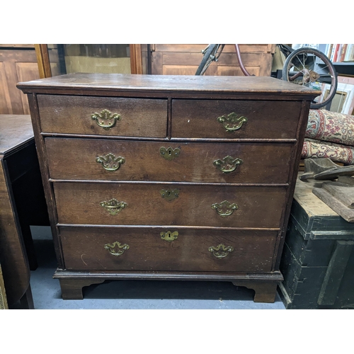 501 - An early 20th century oak chest of drawers with two short, three long drawers with brass swing handl... 