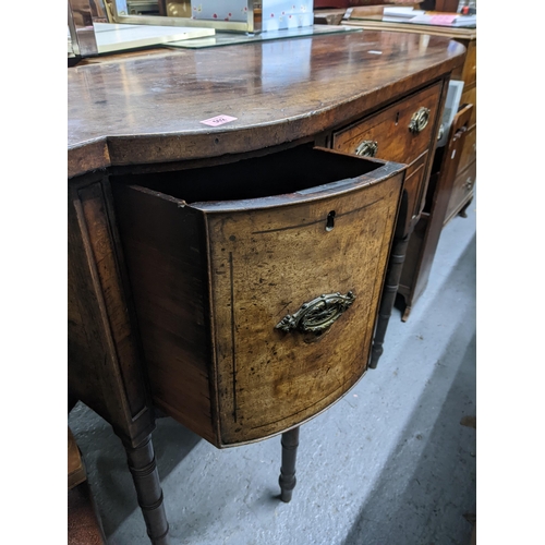 502 - A 19th century bow fronted sideboard with two long drawers, flanked by two deep drawers with brass h... 