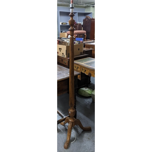 375 - A carved and fluted walnut standard lamp with leaf decoration on tripod legs, 153cm high (without fi... 