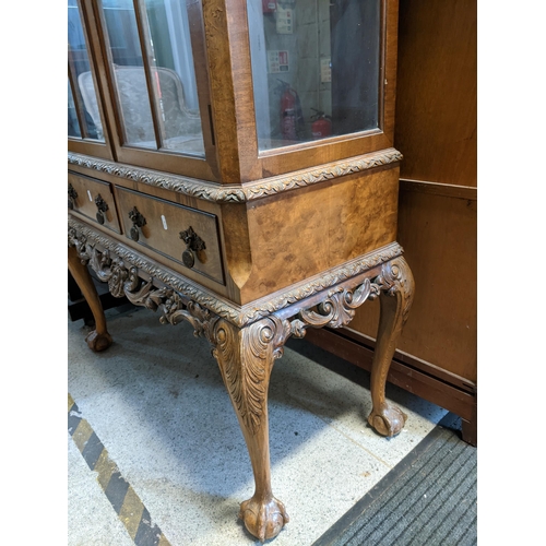 385 - An early 20th century walnut veneered display cabinet, carved rococo leaf design to the arched top, ... 