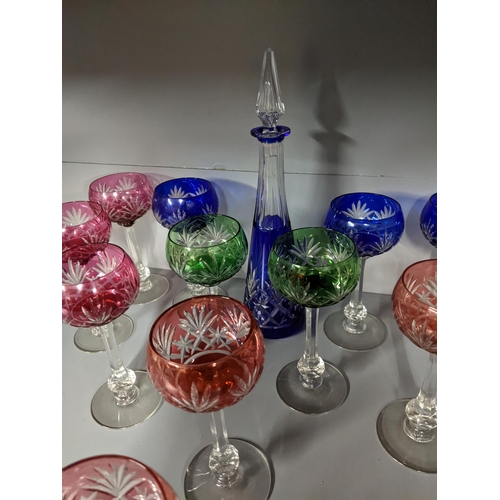 566 - A Harlequin set of eleven hock glasses having ruby, blue, green and cranberry coloured overlaid and ... 