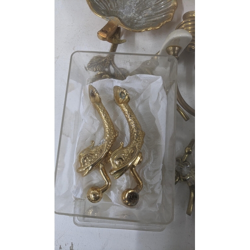 596 - A collection of brass home accessories to include coat hooks, curtain hoops, a pair of door knobs an... 