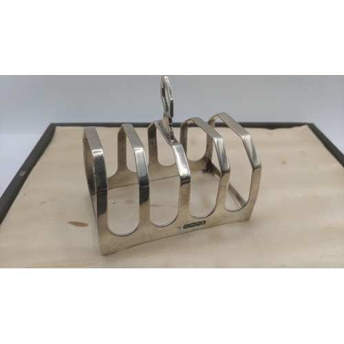 107 - Silver to include a set of six silver handled knives in a fitted case together with a toast rack, we... 