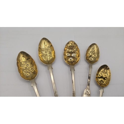 124 - A group of fiddle pattern berry and jam spoons all having embossed and gilded bowls and floral engra... 