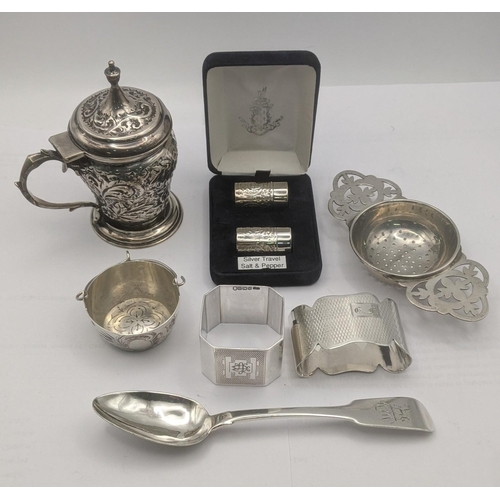 150 - A group of silver items to include a floral embossed mustard pot, salt and pepper travel pots, a fid... 