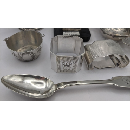 150 - A group of silver items to include a floral embossed mustard pot, salt and pepper travel pots, a fid... 