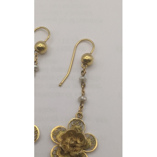 3 - A pair of yellow metal and pearl daisy earrings having a pierced design 4.6g tested as 9ct yellow go... 