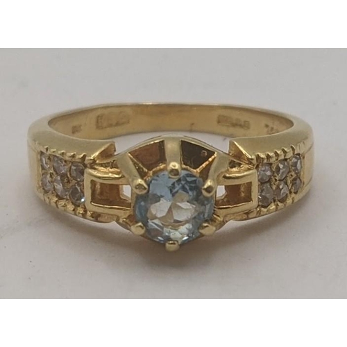 38 - An aquamarine and diamond 18ct yellow gold ring having a central brilliant cut aquamarine in a 6 cla... 