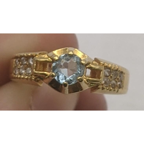 38 - An aquamarine and diamond 18ct yellow gold ring having a central brilliant cut aquamarine in a 6 cla... 