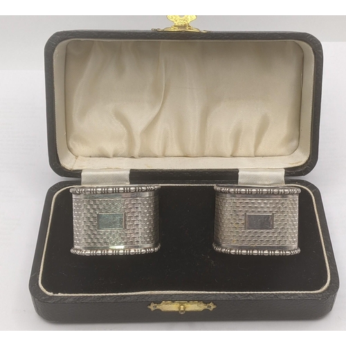 48 - A pair of silver engine turned napkin rings in square form hallmarked Birmingham 1933 house din a fi... 