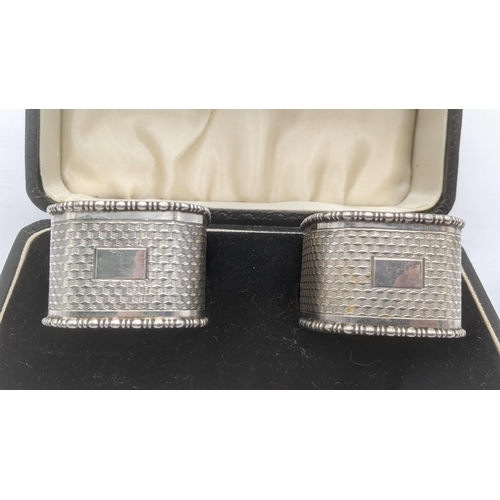 48 - A pair of silver engine turned napkin rings in square form hallmarked Birmingham 1933 house din a fi... 