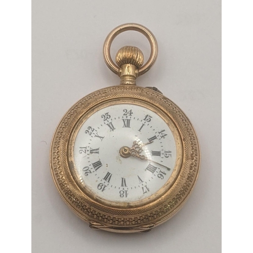 5 - An 18ct yellow gold open faced keyless ladies fob watch having engine turned borders and engraved de... 