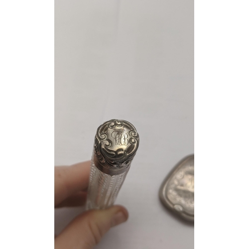 56 - A Victorian lay down perfume bottle having a silver floral embossed lid and engraved initials on a c... 