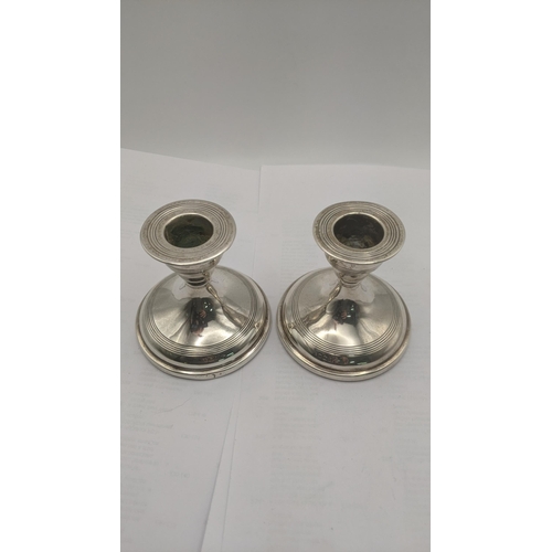 67 - A pair of Walker and Hall silver dwarf candlesticks hallmarked Sheffield 1910 having a circular weig... 