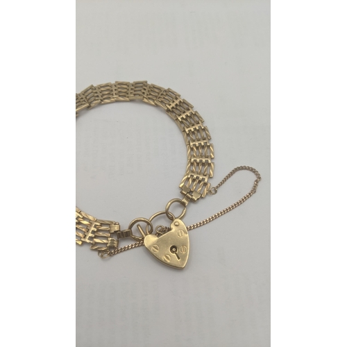 80 - A 9ct yellow gold gate link bracelet with a heart shaped padlock style clasp and safety chain 14.7g
... 