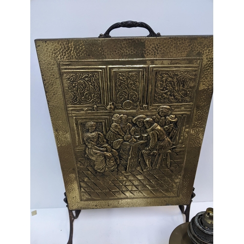 414 - A group of fireside items to include a brass plated fire screen, two copper kettles, a copper footwa... 