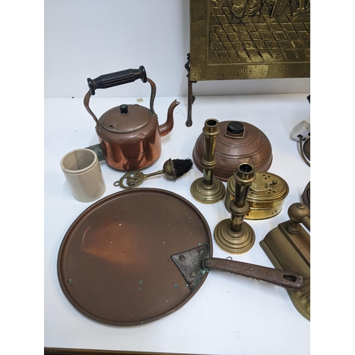 414 - A group of fireside items to include a brass plated fire screen, two copper kettles, a copper footwa... 