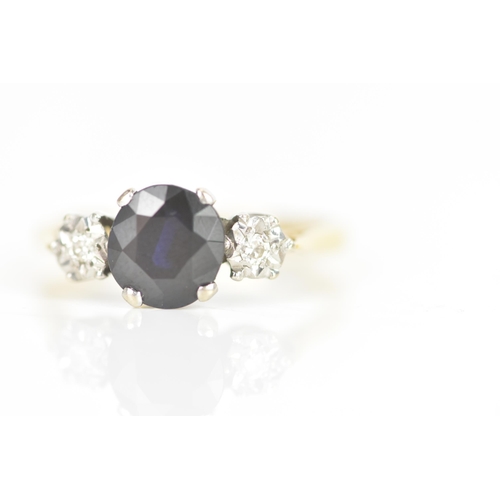 11 - A sapphire and diamond 18ct yellow and white gold engagement ring, the central sapphire calculated a... 