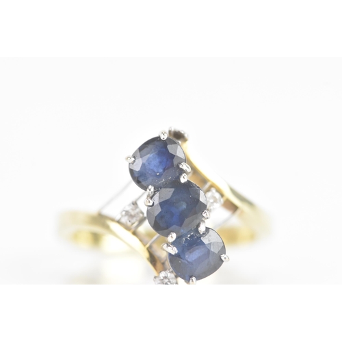 212 - A sapphire and diamond 14ct yellow and white gold dress ring, having three sapphires in four claw se... 