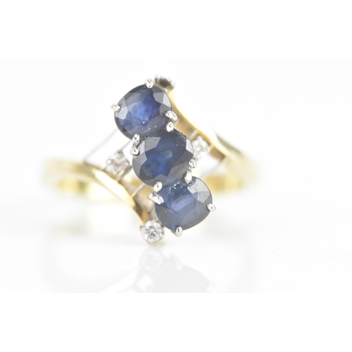 212 - A sapphire and diamond 14ct yellow and white gold dress ring, having three sapphires in four claw se... 