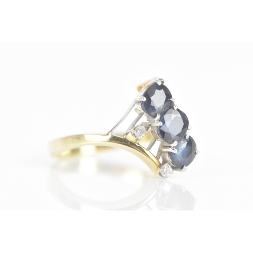 212 - A sapphire and diamond 14ct yellow and white gold dress ring, having three sapphires in four claw se... 