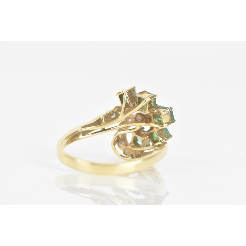 216 - An emerald and diamond 18ct yellow gold dress ring, of scroll design, with five emeralds in claw set... 