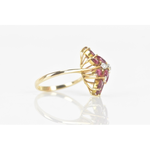 217 - A ruby and diamond 14ct yellow gold cluster dress ring, fashioned as a flower head, with five brilli... 