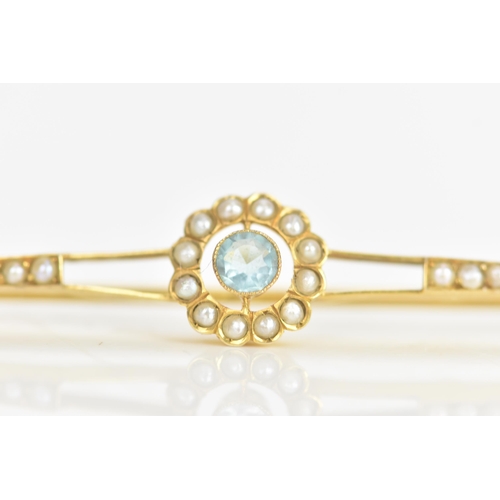 22 - An Edwardian aquamarine and seed pearl 9ct yellow gold bar brooch, the central aquamarine 3.5mm, sur... 