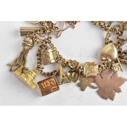 221 - A yellow gold chain link charm bracelet, unmarked, with various 9ct gold and yellow metal charms inc... 