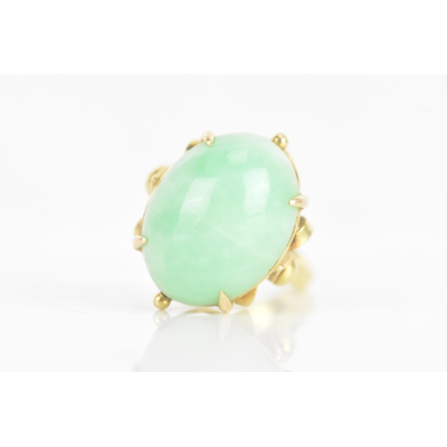 223 - A Chinese jadeite yellow gold dress ring, the oval jadeite cabochon 17.2mm x 12.8mm, in a four claw ... 