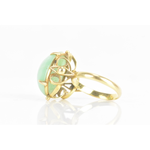 223 - A Chinese jadeite yellow gold dress ring, the oval jadeite cabochon 17.2mm x 12.8mm, in a four claw ... 