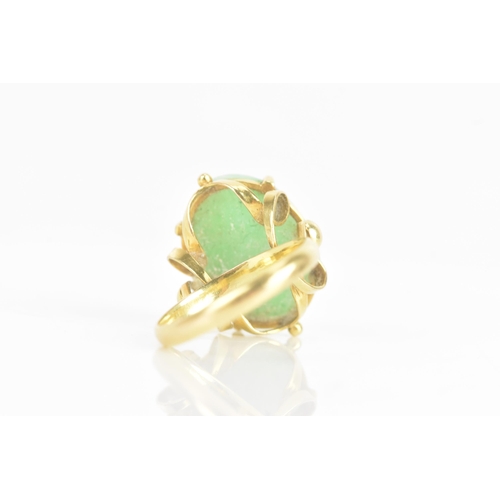 223 - A Chinese jadeite yellow gold dress ring, the oval jadeite cabochon 17.2mm x 12.8mm, in a four claw ... 