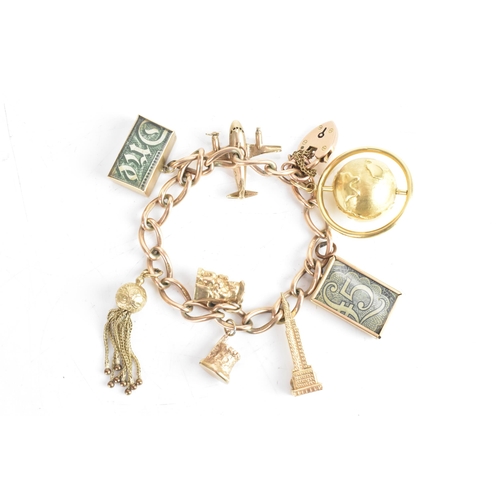 224 - A 9ct yellow gold chain link charm bracelet, with a heart shaped padlock clasp, six 9ct gold charms,... 