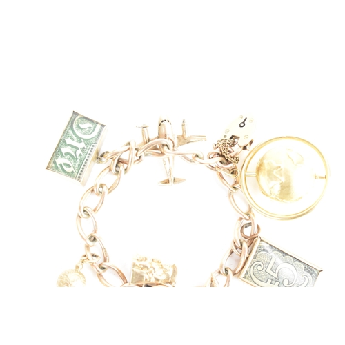 224 - A 9ct yellow gold chain link charm bracelet, with a heart shaped padlock clasp, six 9ct gold charms,... 