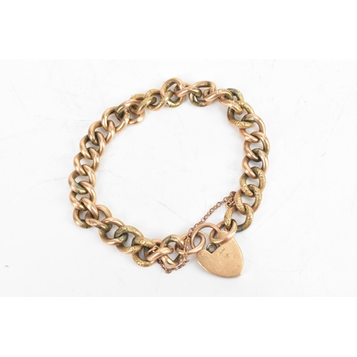 23 - A 9ct rose gold curb link chain bracelet, having a heart shaped padlock clasp and safety chain, stam... 