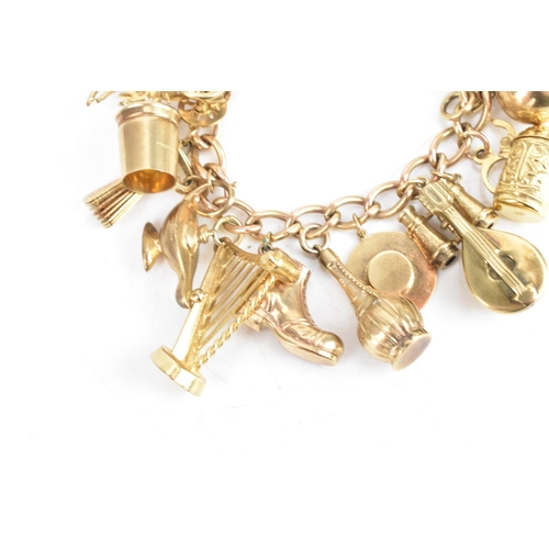 26 - A 9ct yellow gold chain link charm bracelet, with various 9ct gold and yellow metal charms including... 