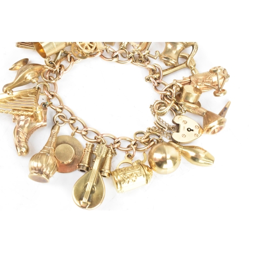 26 - A 9ct yellow gold chain link charm bracelet, with various 9ct gold and yellow metal charms including... 